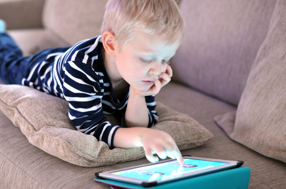 young boy playing on tablet