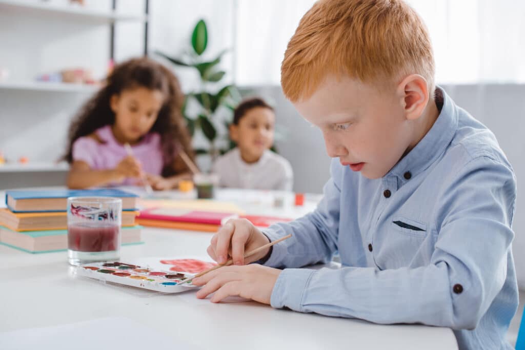 boy intensely focusing on paint